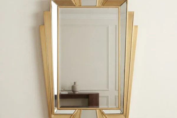 A geometric Art Deco Carolina Mirror Company mirror with a stepped, polished gilt frame.